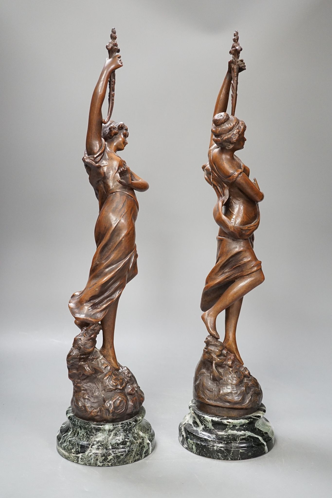 A pair of bronze female dancers, on marble plinths, 47cm